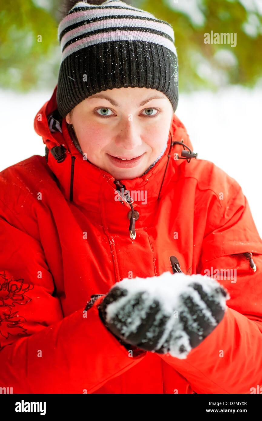 Retrato de una mujer que mantiene un puñado de nieve en sus manos Foto de stock