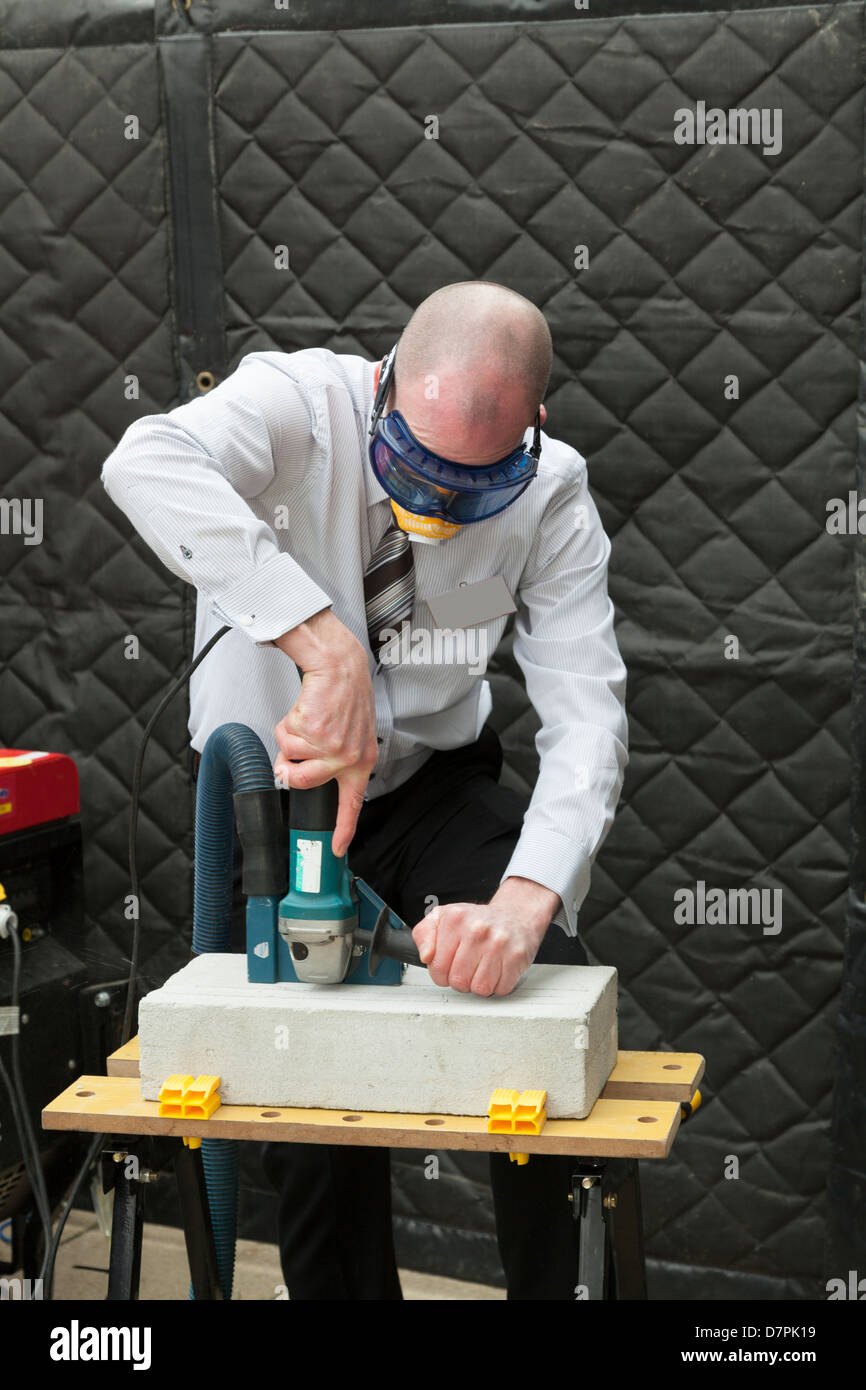 El hombre demostrando la extracción de polvo en Power Tool Foto de stock