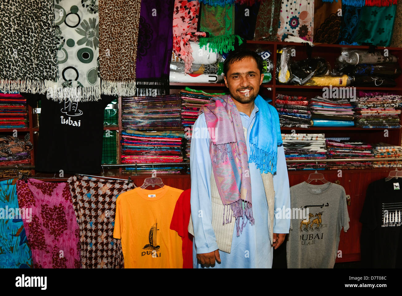 Árabe local hombre fotografiado junto al estante de ropa dentro de su  tienda en el antiguo zoco, Dubai Fotografía de stock - Alamy