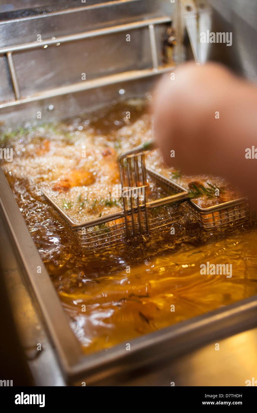 Pollo frito en la freidora Fotografía de stock - Alamy