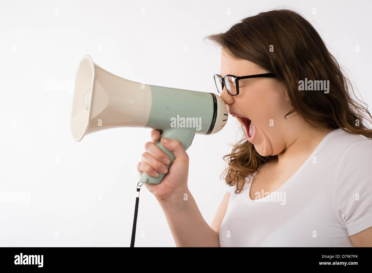 Una joven morenita adolescente chica caucásica gritando en un megáfono con gafas de cuerno de toro gritando gritando uk Foto de stock