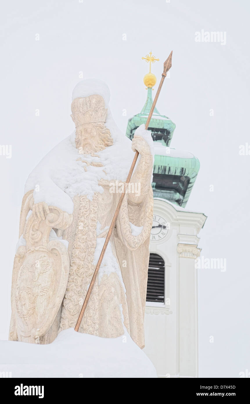Estatua de un santo con nieve sobre ella Foto de stock