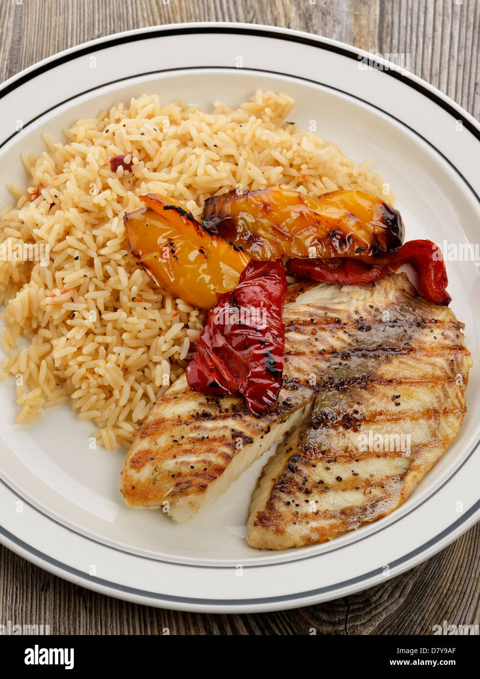 Filete de tilapia asado con arroz y verduras Foto de stock