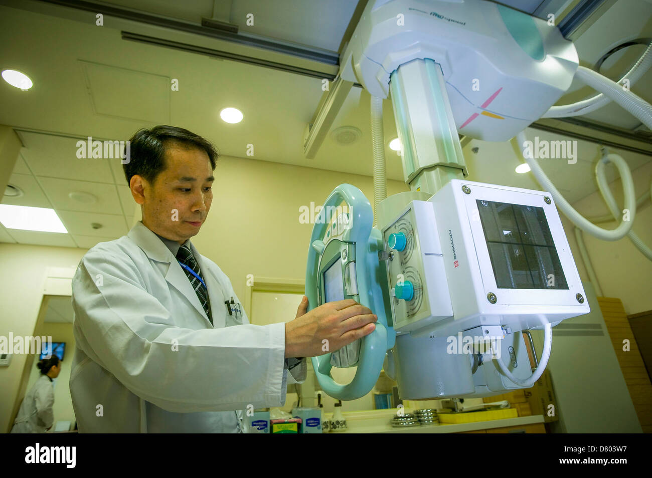Un radiólogo ajusta una máquina de rayos X antes de su uso. Foto de stock