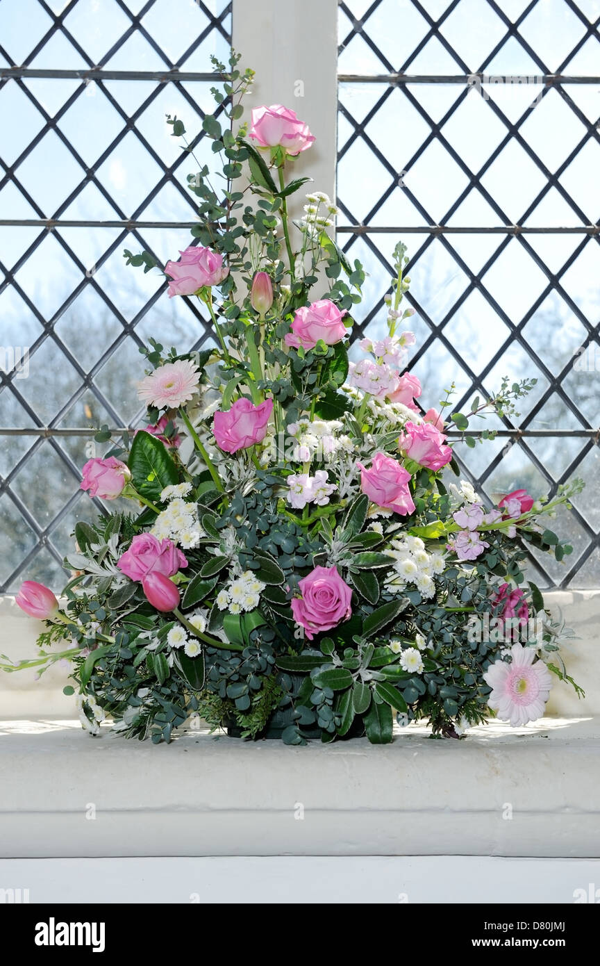 Arreglo de flores en el día de la boda en la iglesia con rosas rosas Foto de stock