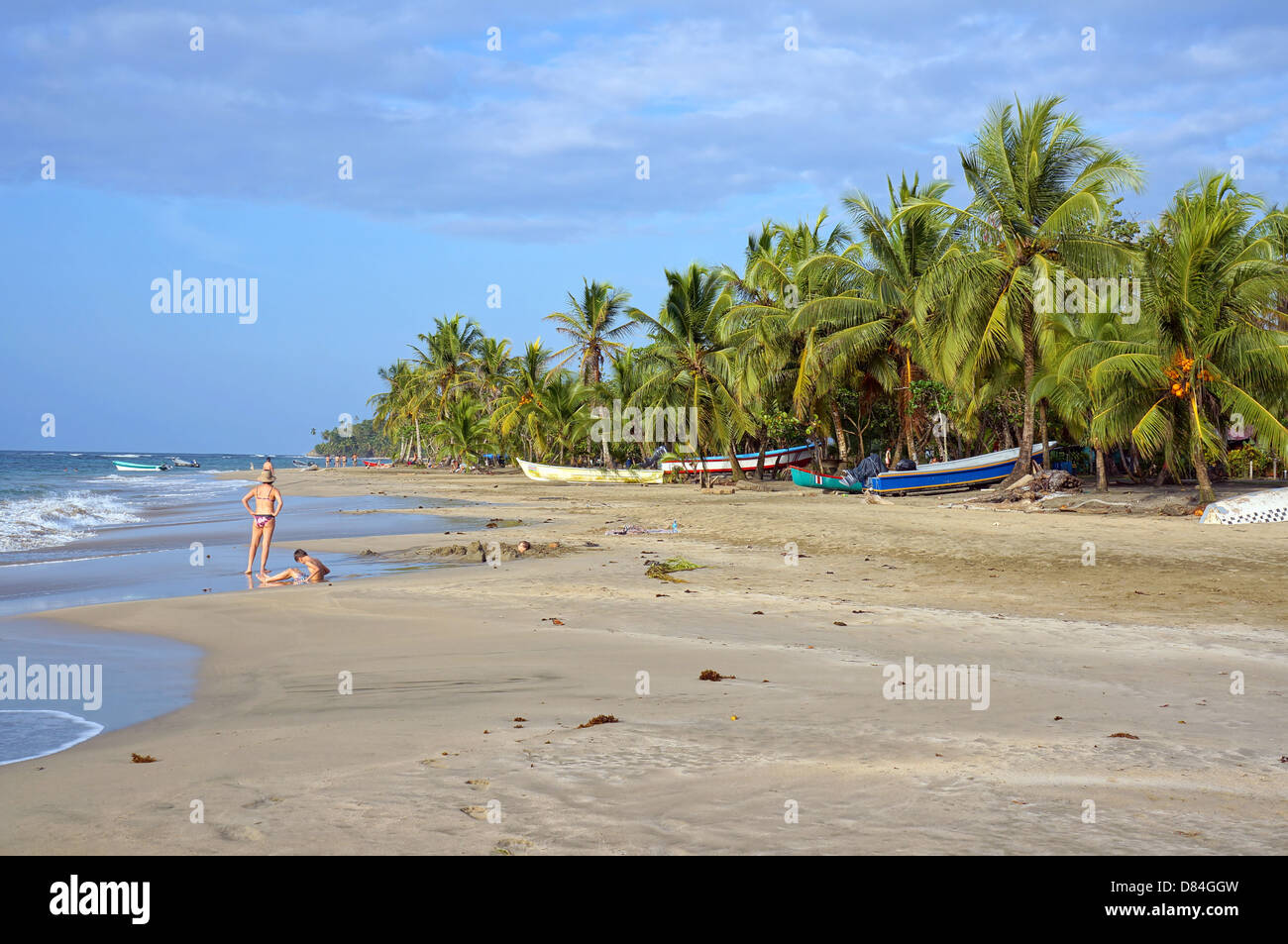 Playa Tropical con botes de pesca bajo los cocoteros, el Caribe, Manzanillo, Costa Rica Foto de stock