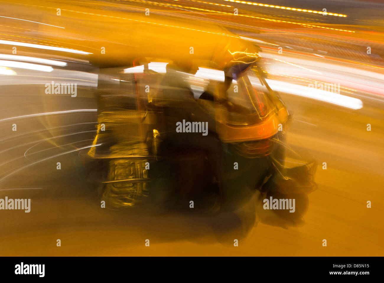 La India, Uttar Pradesh, Nueva Delhi, rickshaws y tráfico en la noche con efecto movimiento borrosa Foto de stock