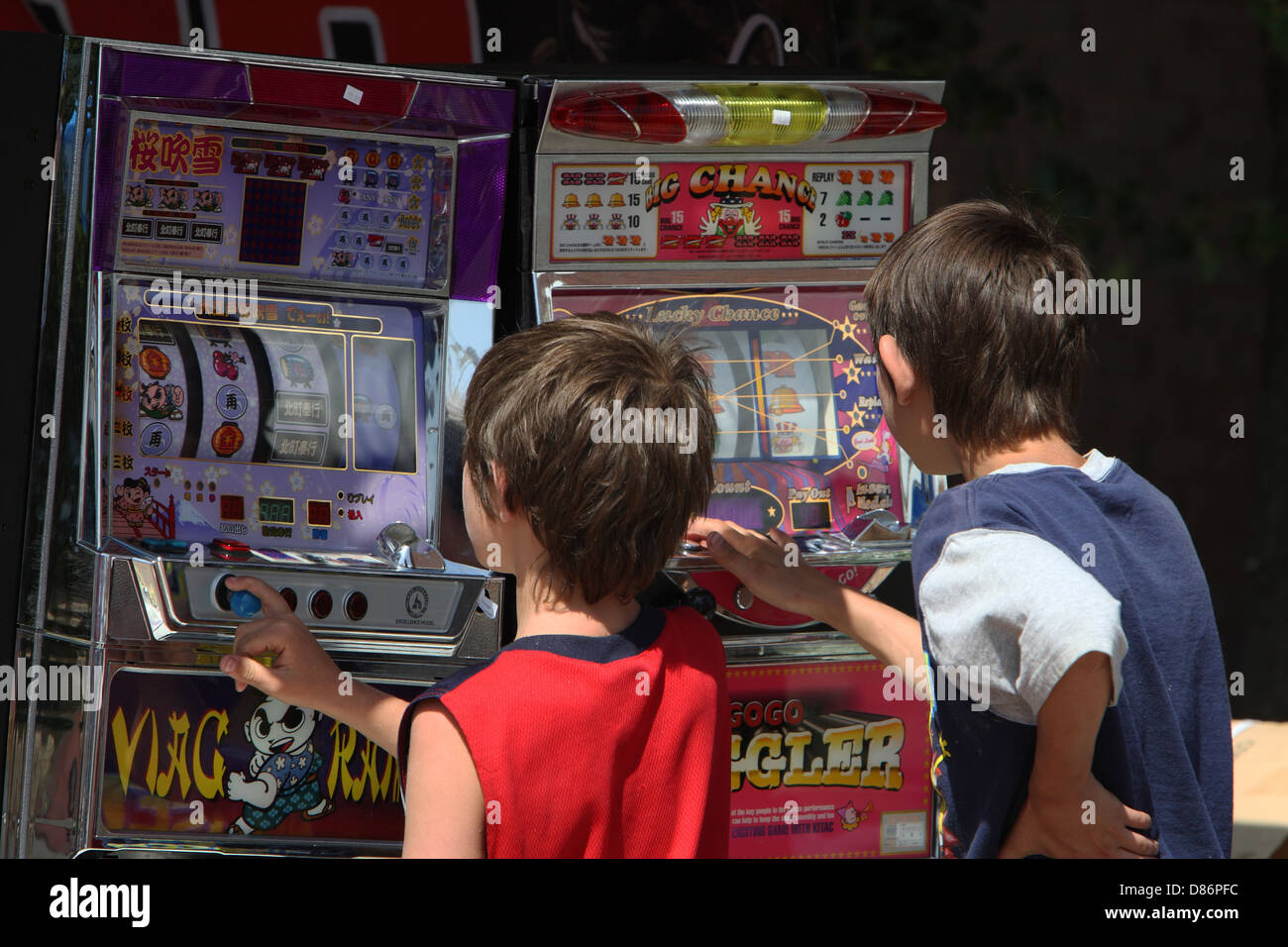 Niños jugando a las tragaperras de frutas Fotografía de stock - Alamy