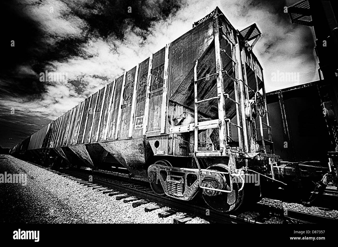 Esta es una imagen en blanco y negro de los vagones de tren sobre las vías de ferrocarril. Foto de stock