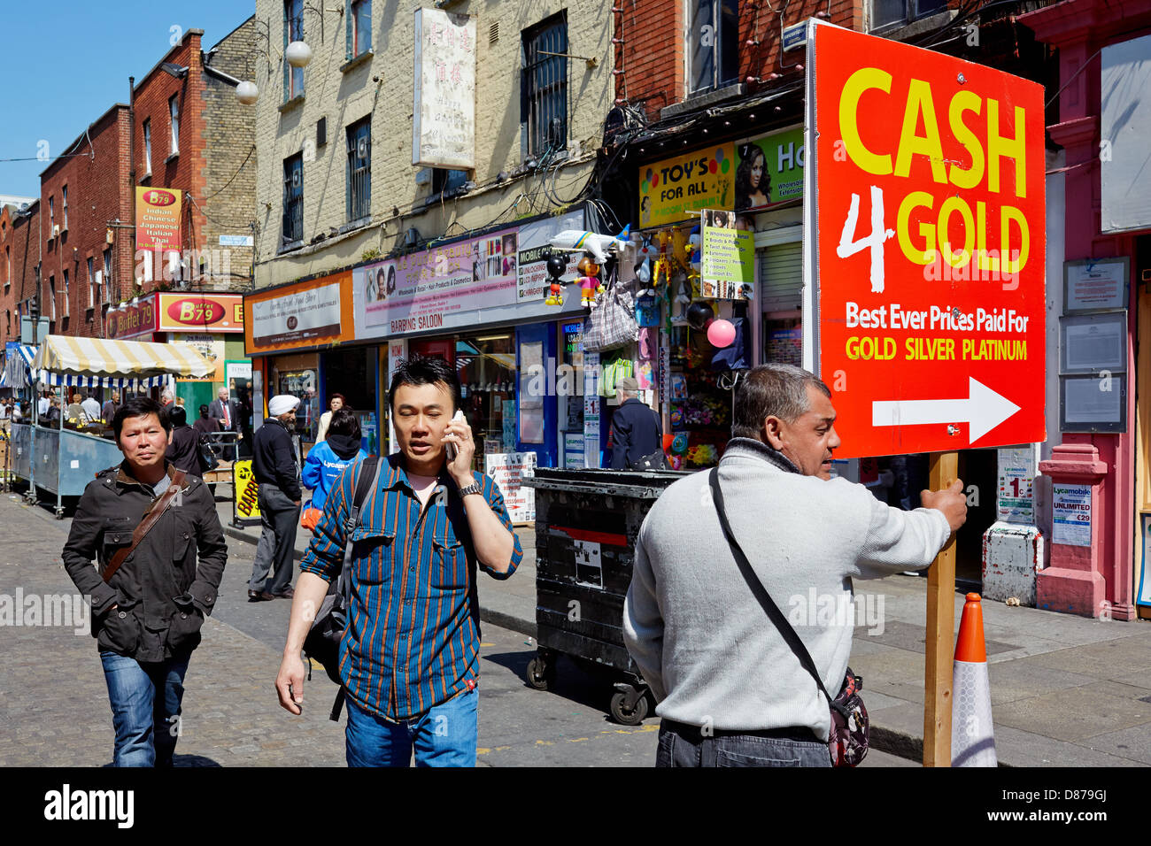 Hombre sujetando cartel publicitario efectivo para el oro durante la recesión económica de 2013. Moore Street, Dublín, República de Irlanda. Foto de stock