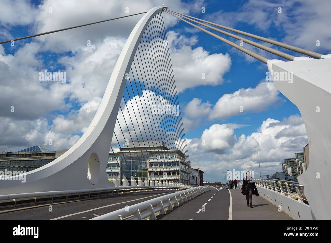 Los peatones cruzan el puente Samuel Beckett, que cruza el río Liffey, uniéndose a Sir John Rogerson's Quay para pared norte Foto de stock