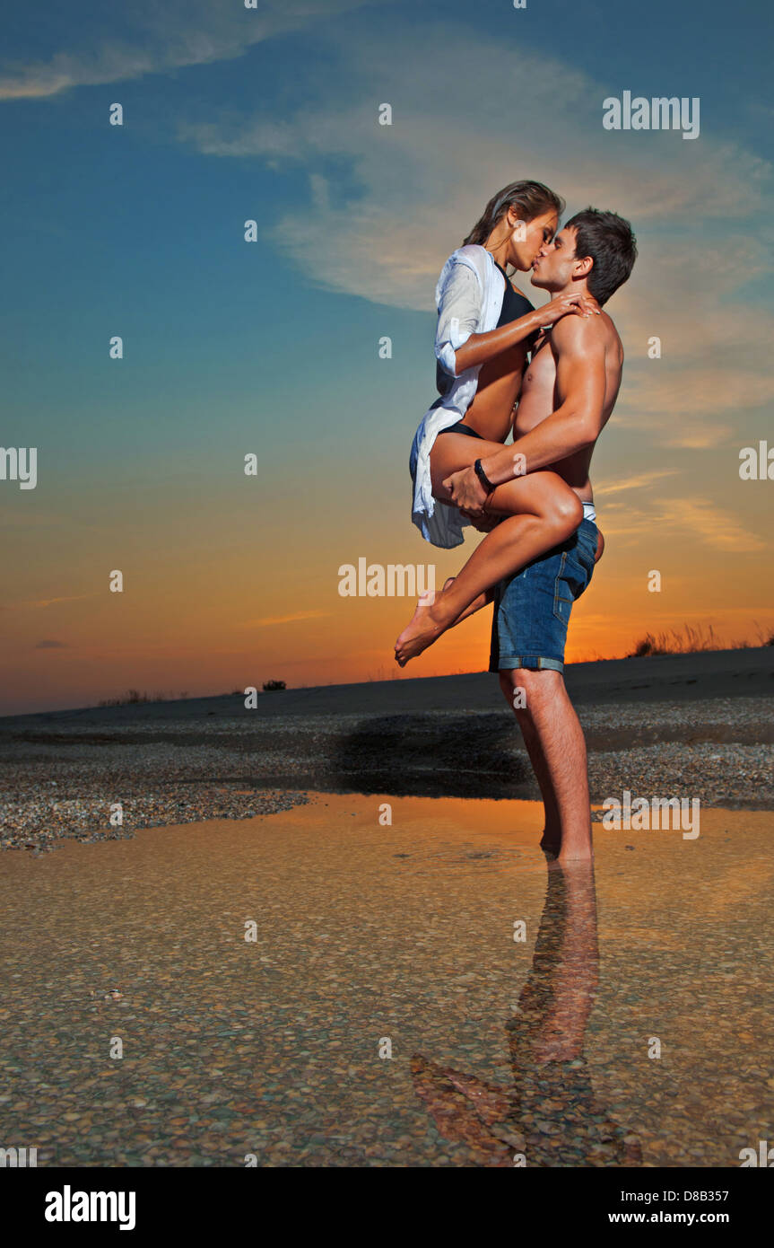 Joven pareja besándose en la playa con el sol detrás de ellos Fotografía de stock - Alamy Joven pareja besándose en la playa con el sol detrás de ellos Fotografía de stock - Alamy