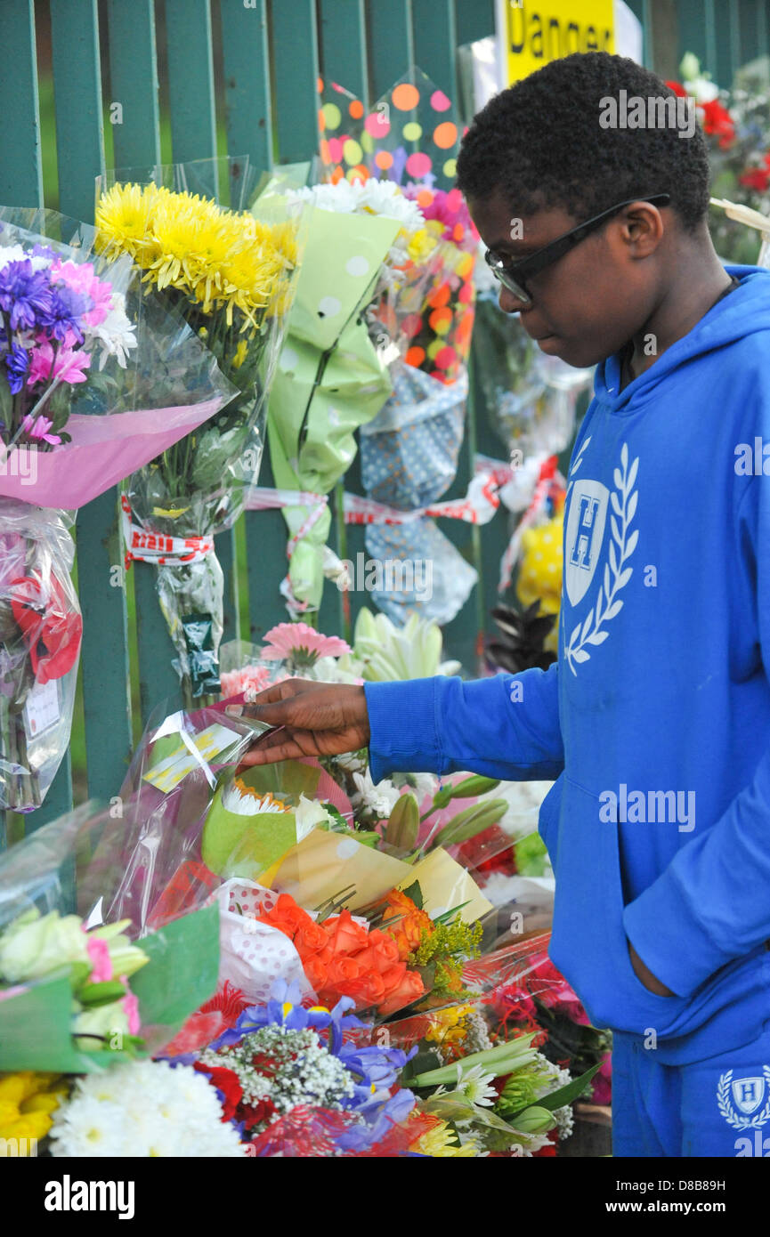 Woolwich, Londres, Reino Unido. 23 de mayo de 2013. Un joven mira las tarjetas y flores en las rejas cerca del lugar del asesinato. Las flores son dejados por admiradores a lo largo de las barandillas, cerca del sitio donde el baterista Lee Rigby del Segundo Batallón del Regimiento Real de Fusiliers fue asesinado fuera de Woolwich cuarteles ayer. Crédito: Matthew Chattle/Alamy Live News Foto de stock
