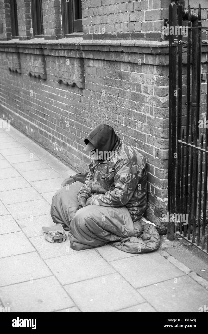 Personas sin hogar hombre sentado pidiendo limosna en las calles de Salisbury Foto de stock