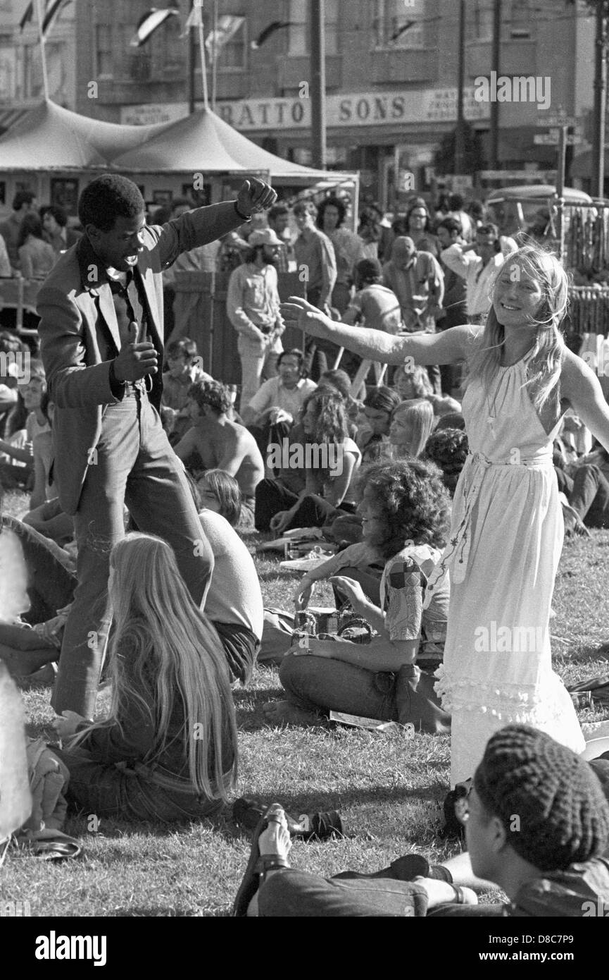 Hombre negro y hippie mujer baila en el festival de música en 1960 Foto de stock