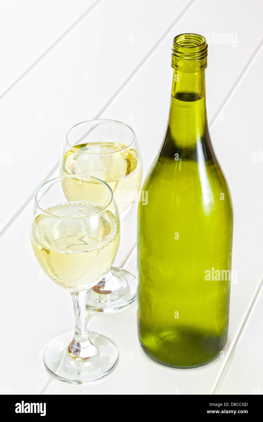 Botella de vino blanco y gafas - Botella de vino blanco frío, con dos copas de vino. Foto de stock