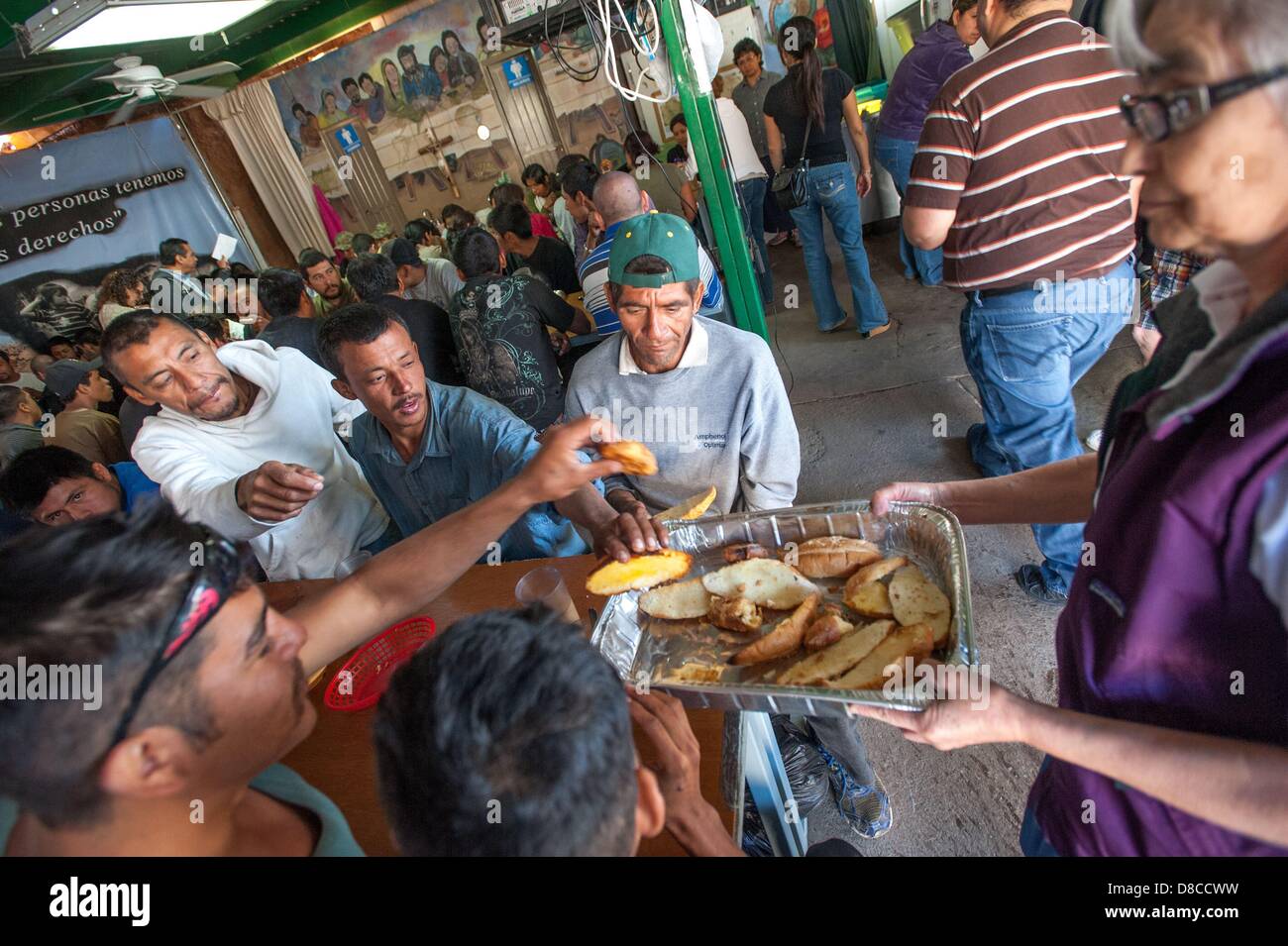 Abril 25, 2013 - Nogales, Sonora, México - hombres alcanzan para pan  ofrecido por la hermana ENGRACIA Robles, a la derecha, la monja que opera  el comedor en Nogales, Son., Mex. El