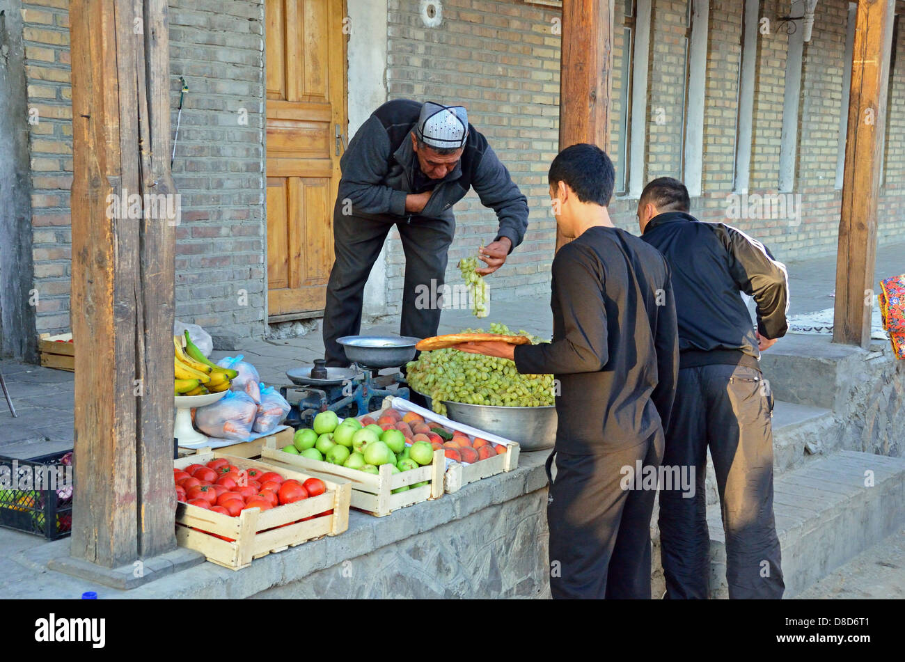 Hombre uzbeko vendiendo frutas en Bukhara después del final del Ramadán Foto de stock
