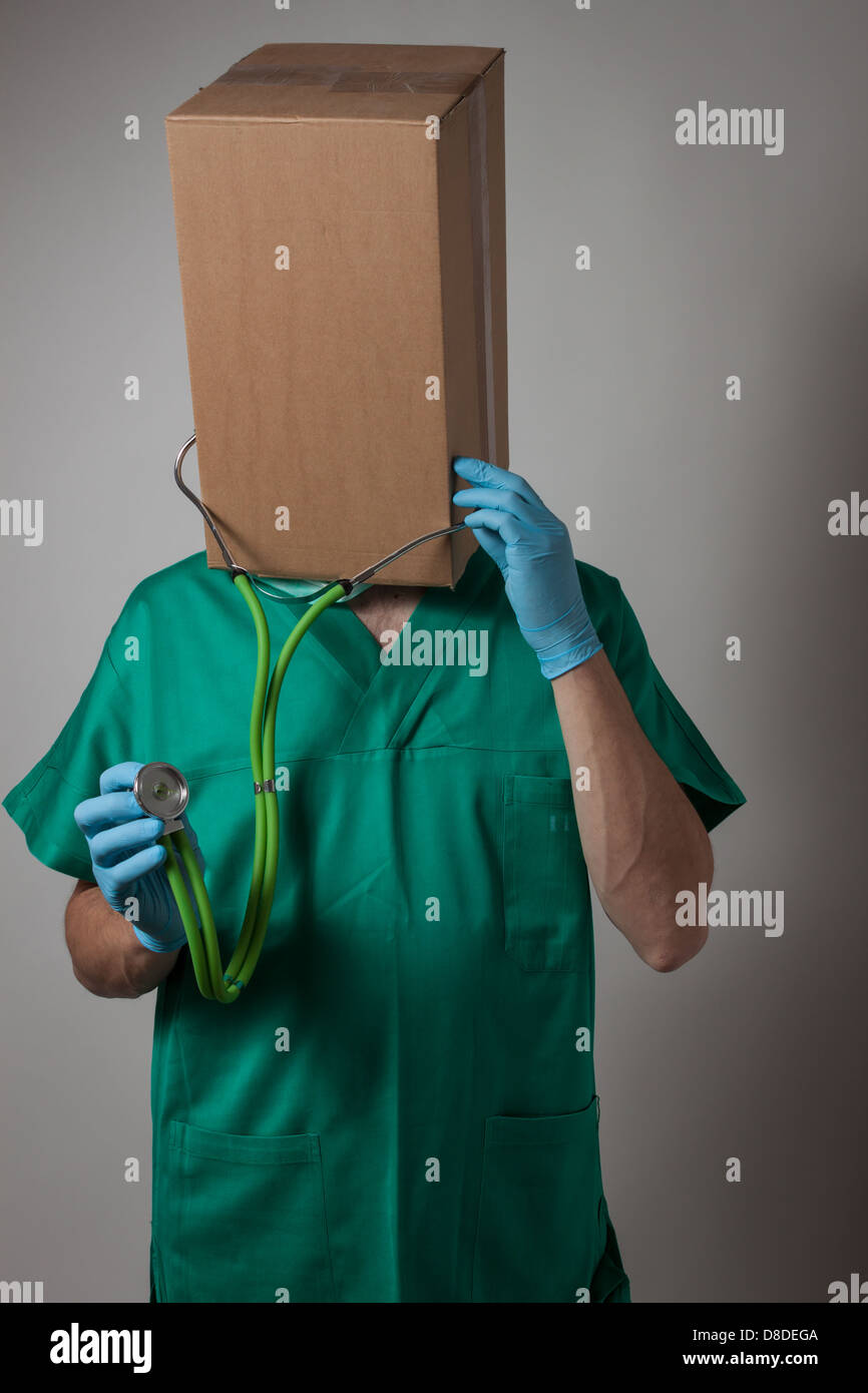 Doctor con caja de cartón en la cabeza uniforme verde Foto de stock