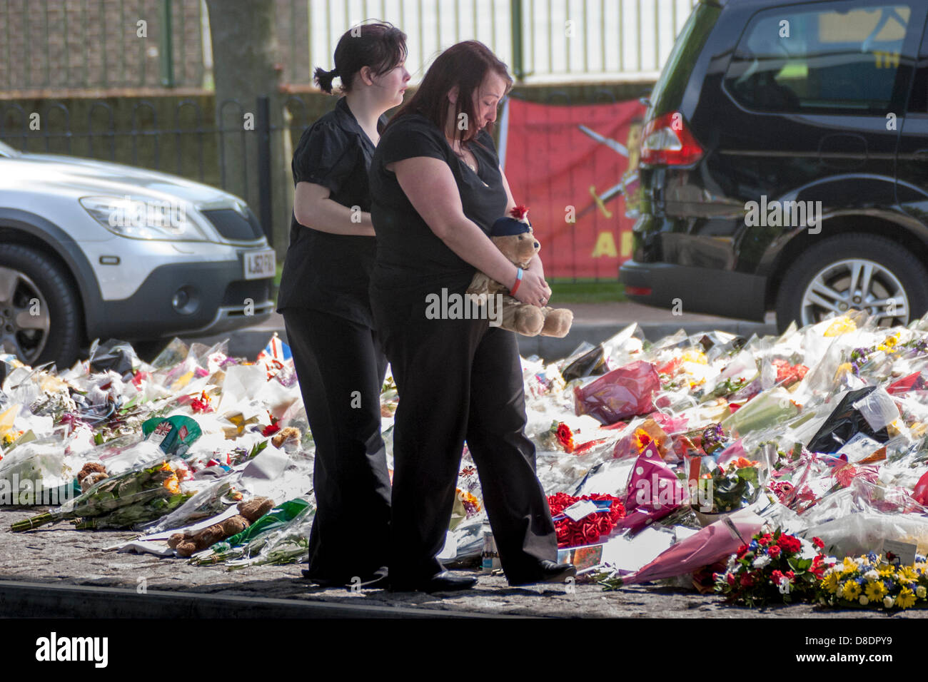 Londres, Reino Unido. El 26 de mayo, 2013. Los miembros de la familia al examinar muchos miles de homenajes florales dejó fuera del real cuartel de artillería de Woolwich, donde asesinaron a soldado, el baterista Lee Rigby trabajaba y vivía. Crédito: Paul Davey/Alamy Live News Foto de stock