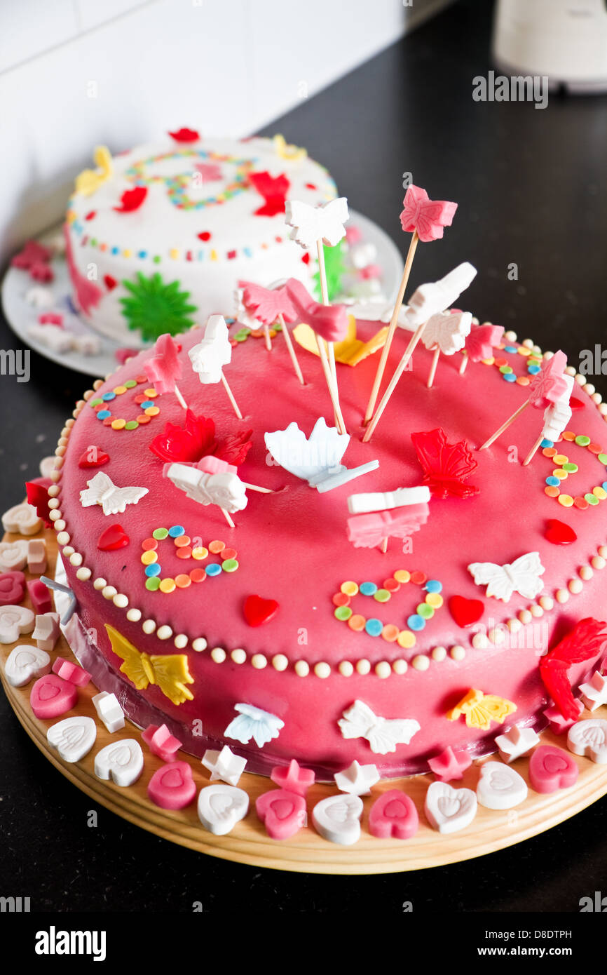 Delicioso colorido decorado de rosa y blanco mazapán pasteles para una fiesta de cumpleaños en el aparador de cocina Foto de stock