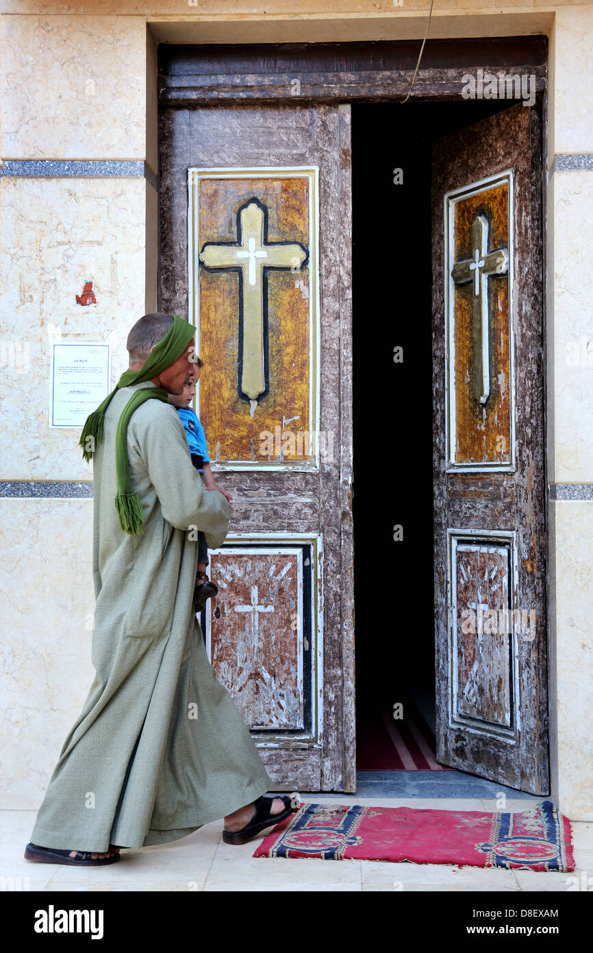 Hombre y niño entrando en la iglesia cristiana copta católica en al iglesia Ghanayem, diócesis de Asyut, Egipto Fotografía de stock - Alamy Hombre y niño entrando en la iglesia cristiana copta católica en al iglesia Ghanayem, diócesis de Asyut, Egipto Fotografía de stock - Alamy