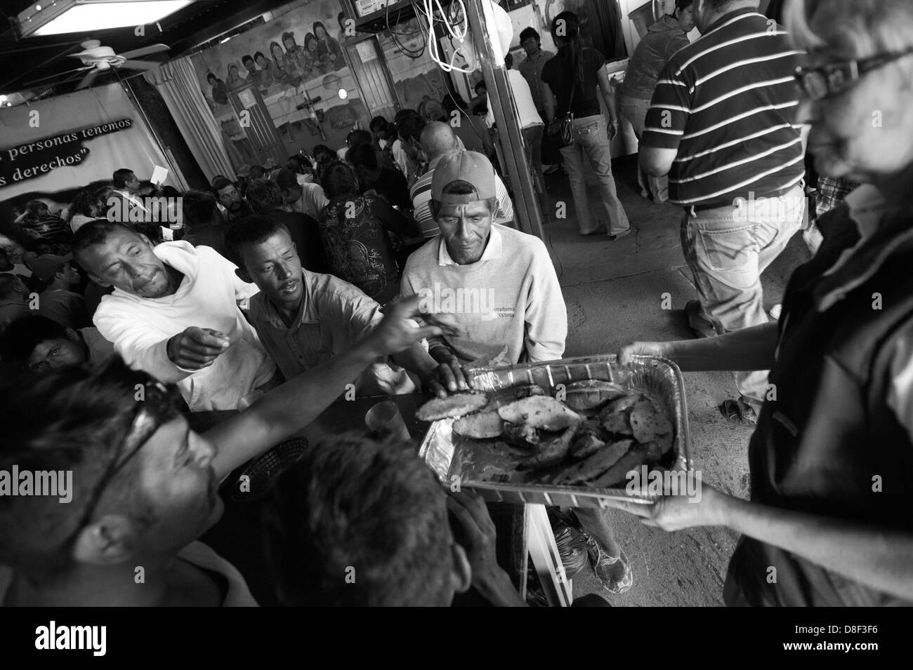 Abril 25, 2013 - Nogales, Sonora, México - hombres alcanzan para pan  ofrecido por la hermana ENGRACIA ROBLES , la monja que opera el comedor en  Nogales, Son., Mex. El Comedor ofrece