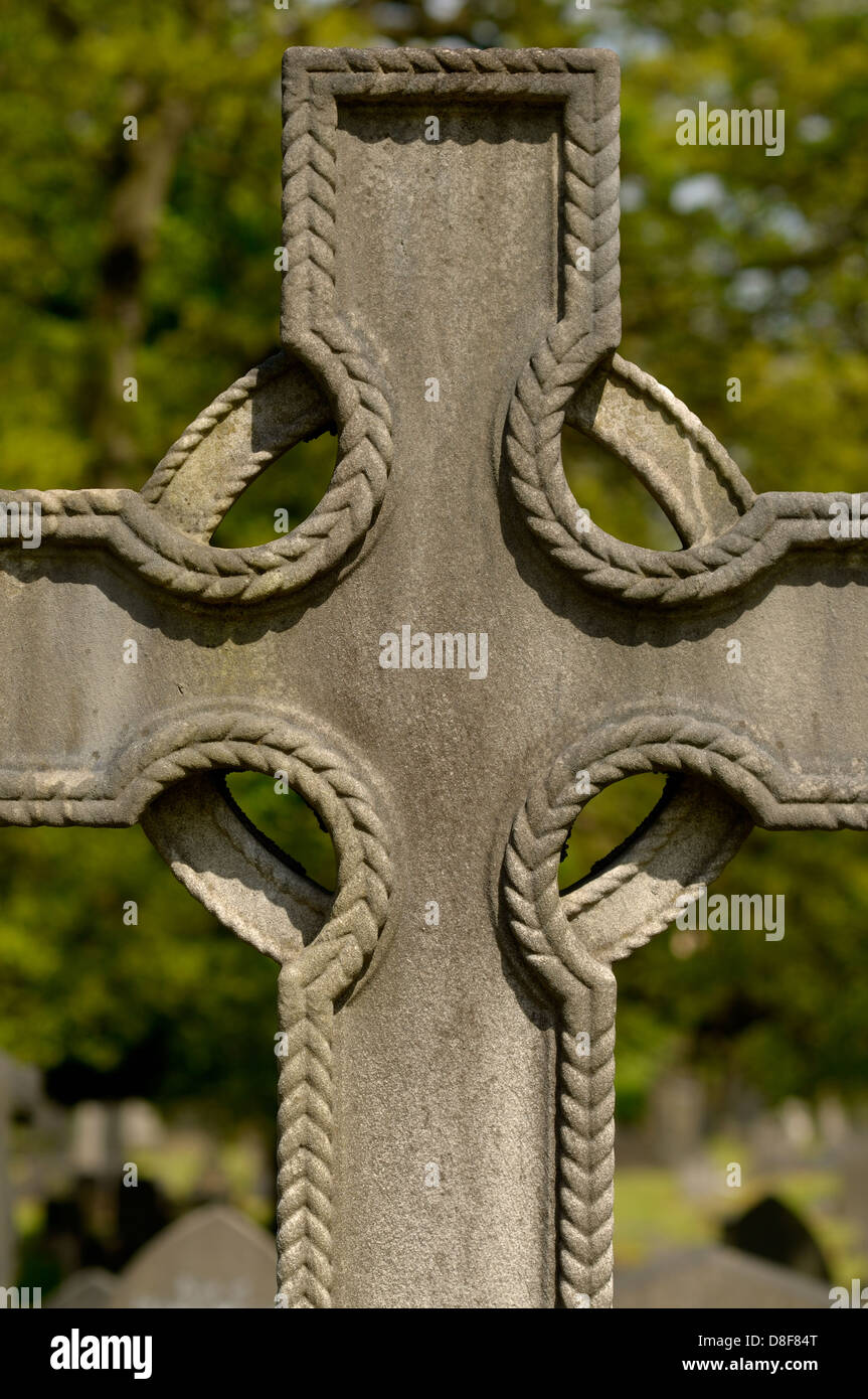 Una cruz de piedra marca el sitio de una tumba. Foto de stock