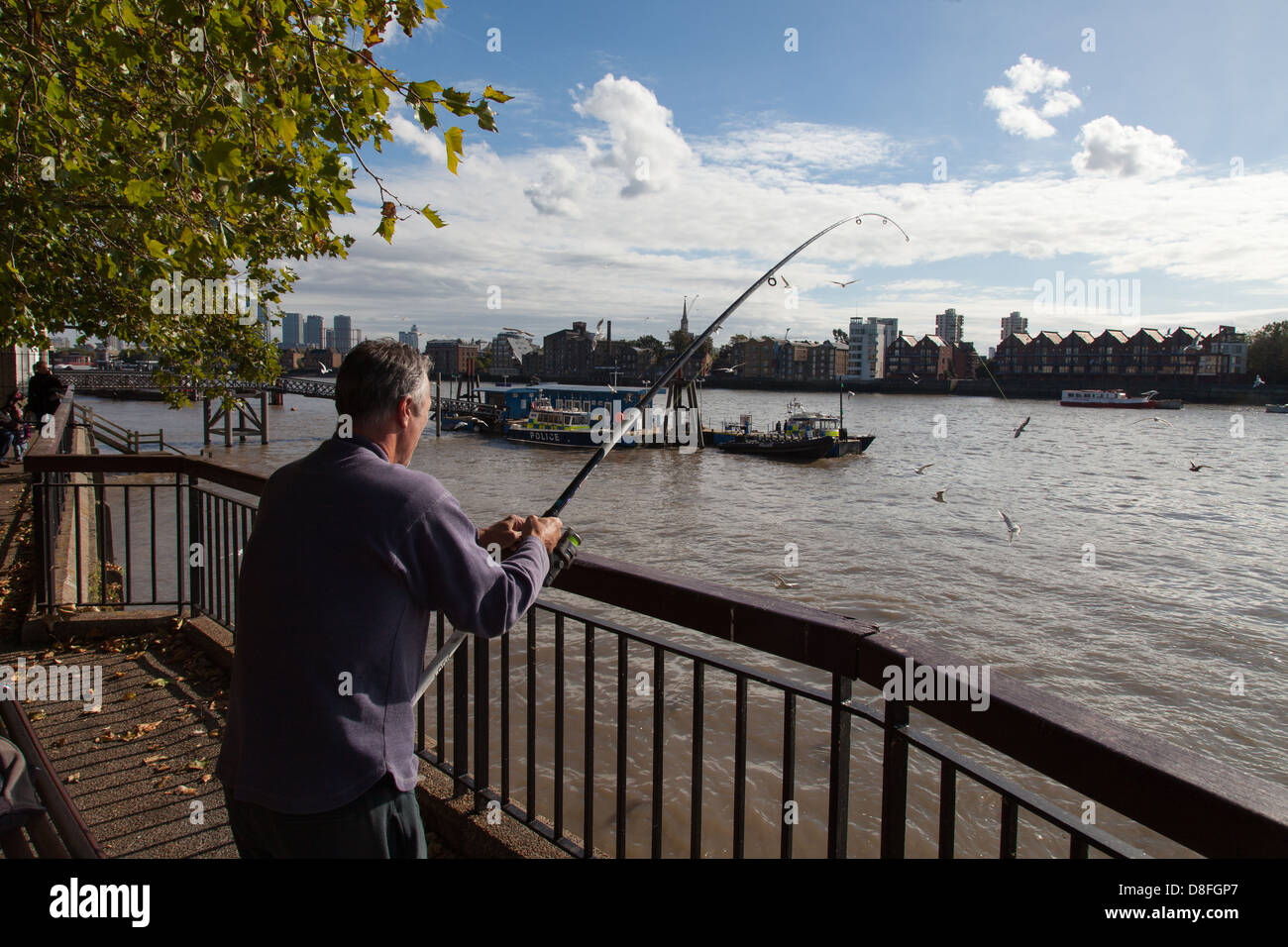 Hombre de pesca de la anguila en el río Támesis, Londres Foto de stock