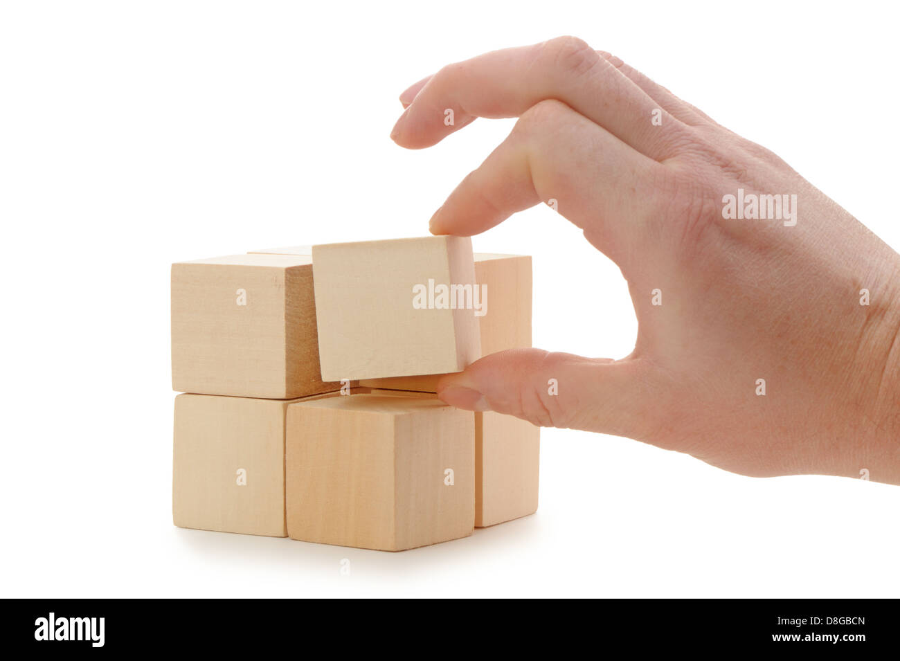 La mano se establece un cubo de madera Foto de stock