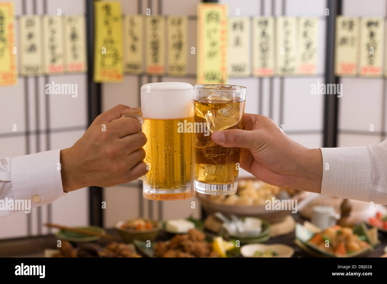 Dos personas con cerveza y tostado en Izakaya Chu-Hi Foto de stock
