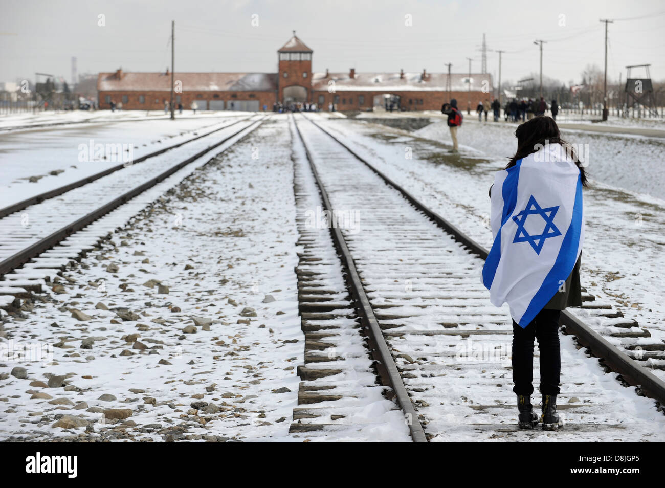 Oswiecim Polonia Auschwitz Birkenau II, campo de concentración del régimen nazi alemán, donde más de 1 millones de judíos fueron asesinados por las SS en cámaras de gas, la mujer Israelí de duelo con la bandera de Israel Foto de stock