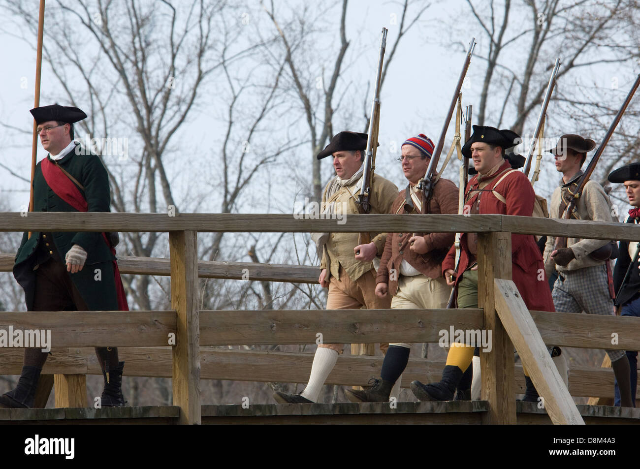 Minutemen recreacions cruzando el Puente de Concord a harrass la retirada británica. Fotografía Digital. Foto de stock