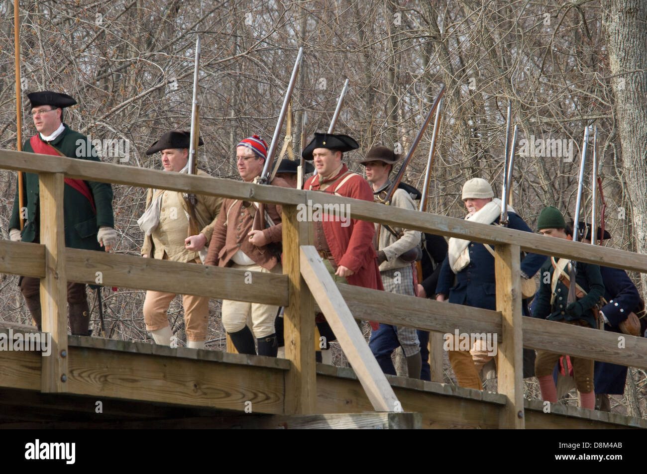 Minutemen recreacions cruzando el Puente de Concord a harrass la retirada británica. Fotografía Digital. Foto de stock