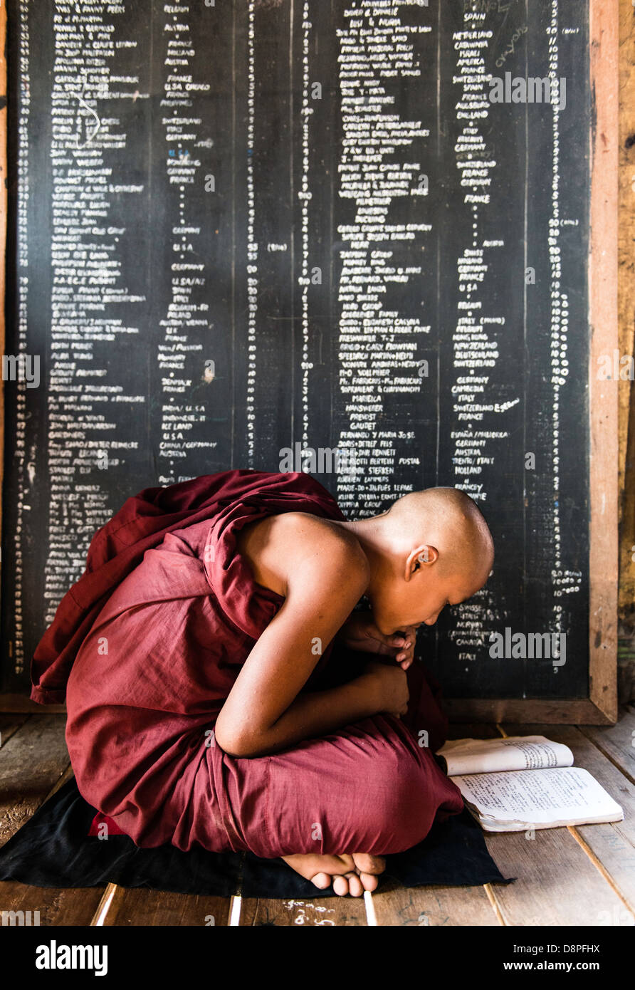 Monje budista estudiando en un monasterio cerca de Mandalay, Birmania Myanmar Foto de stock