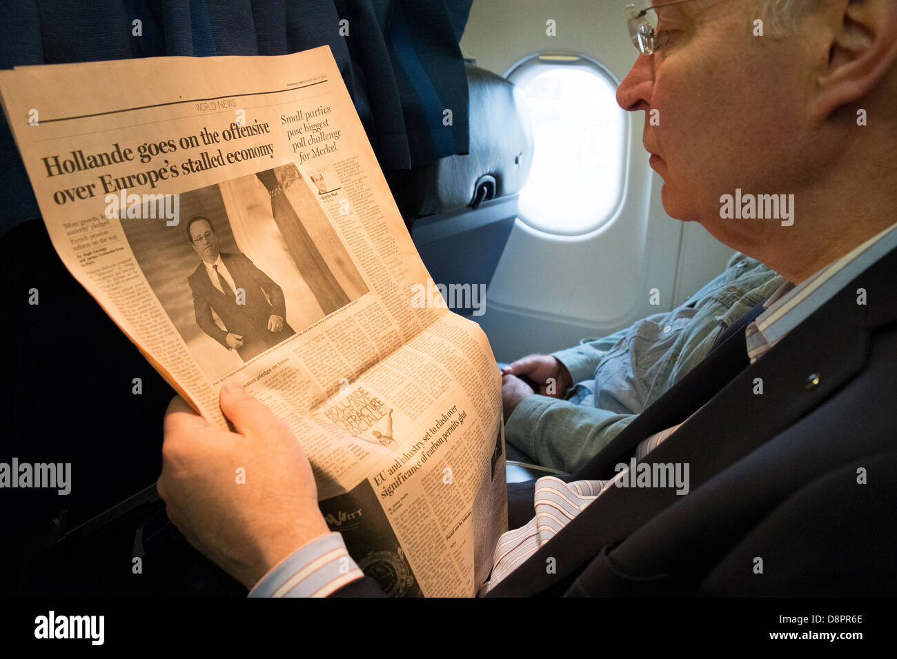 La lectura de periódicos en avión Foto de stock