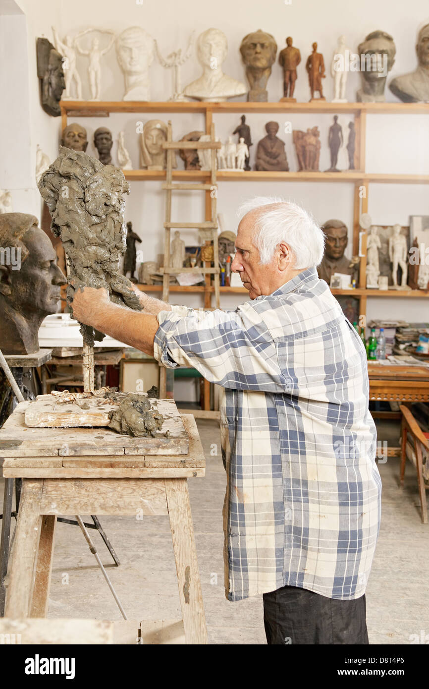 Escultor Senior haciendo escultura vista de perfil Foto de stock