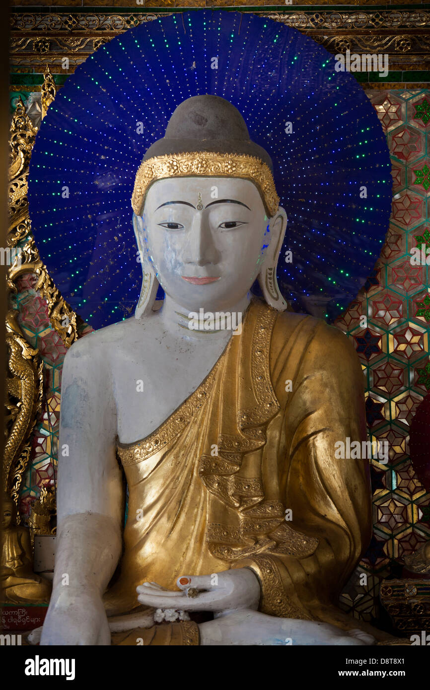 Muchas figuras de Buddha en las capillas laterales en el templo Schwedagon tienen halos de color azul con luces parpadeantes hacer patrones. Foto de stock