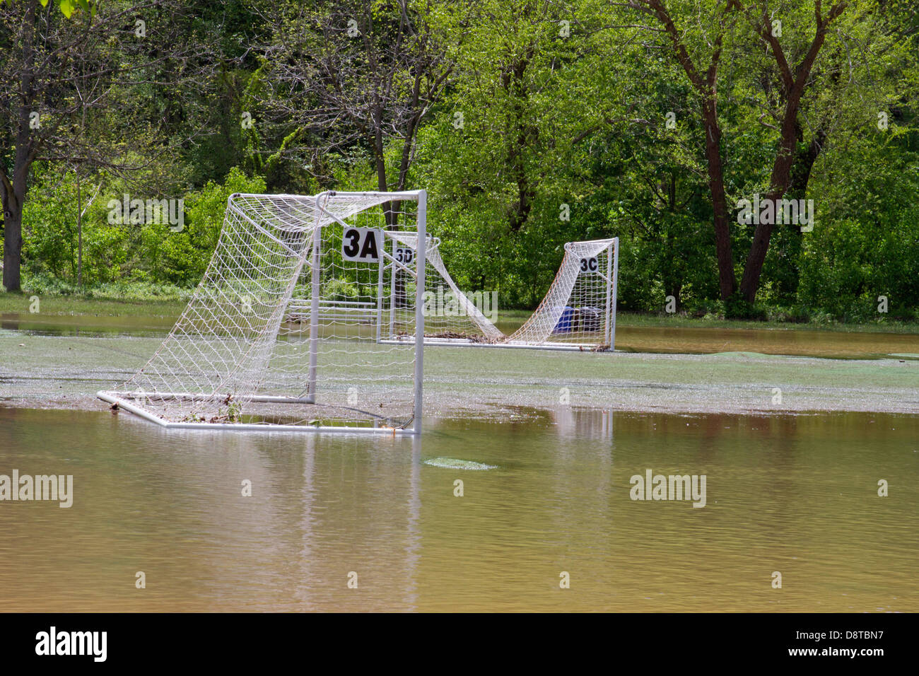 Un campo de fútbol y redes cubiertas por un río inundado Foto de stock
