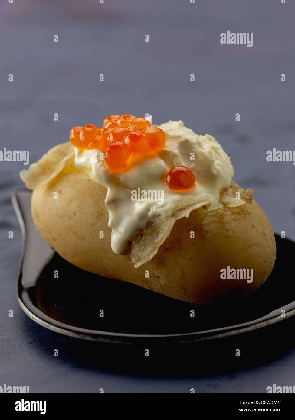 Papa asada con crema y huevas de salmón Foto de stock