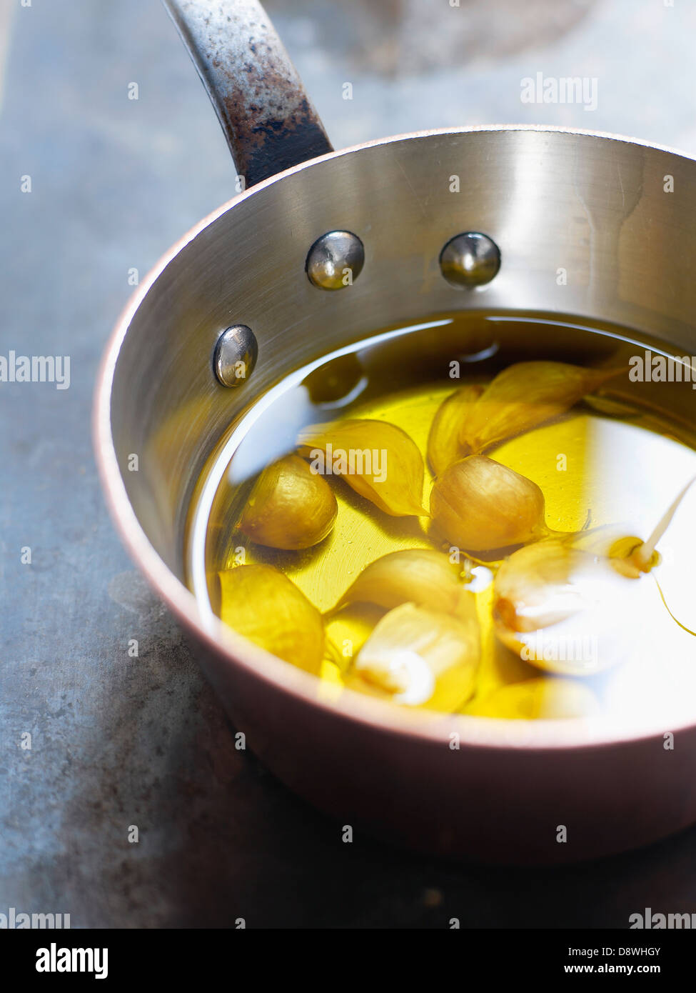 Dientes de ajo en un caldero de aceite de oliva Foto de stock