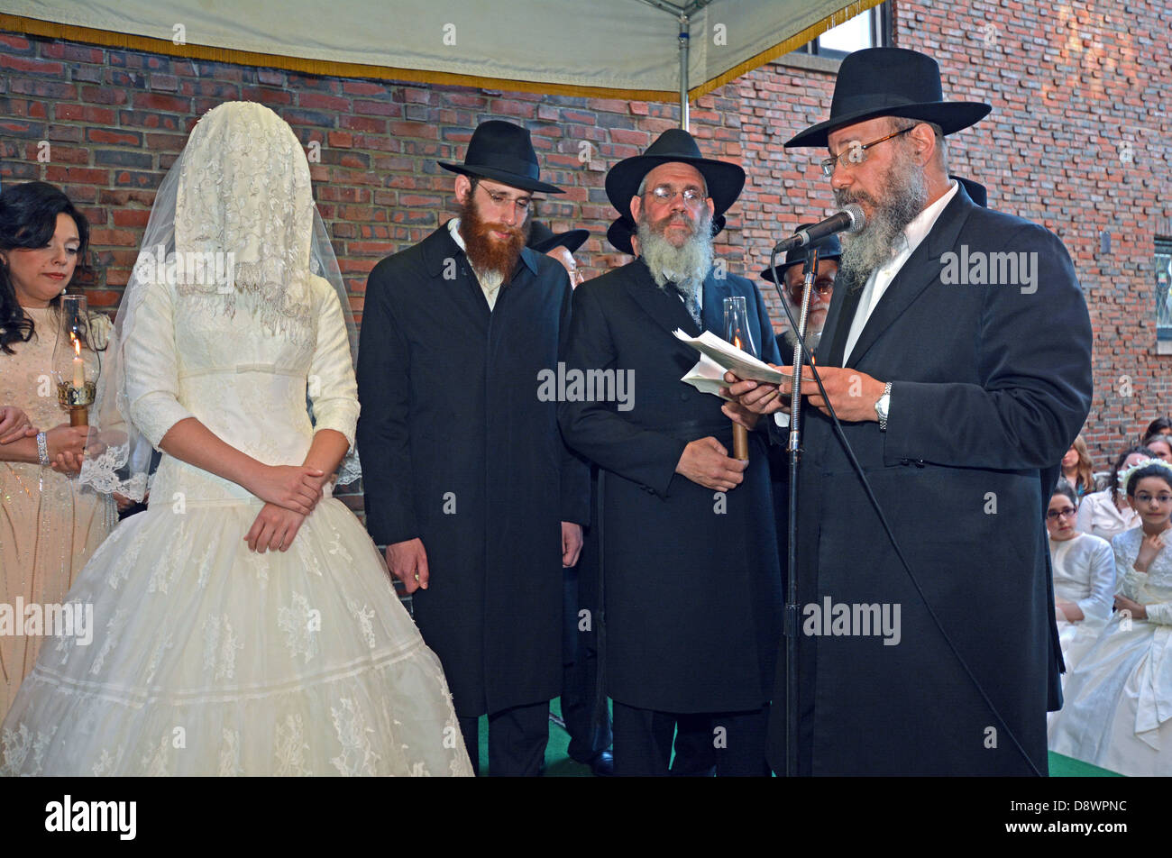 Una religiosa ortodoxa para el novio y la Novia judía bajo un toldo en su ceremonia de boda en Lubavitch sede en Brooklyn, NY Foto de stock