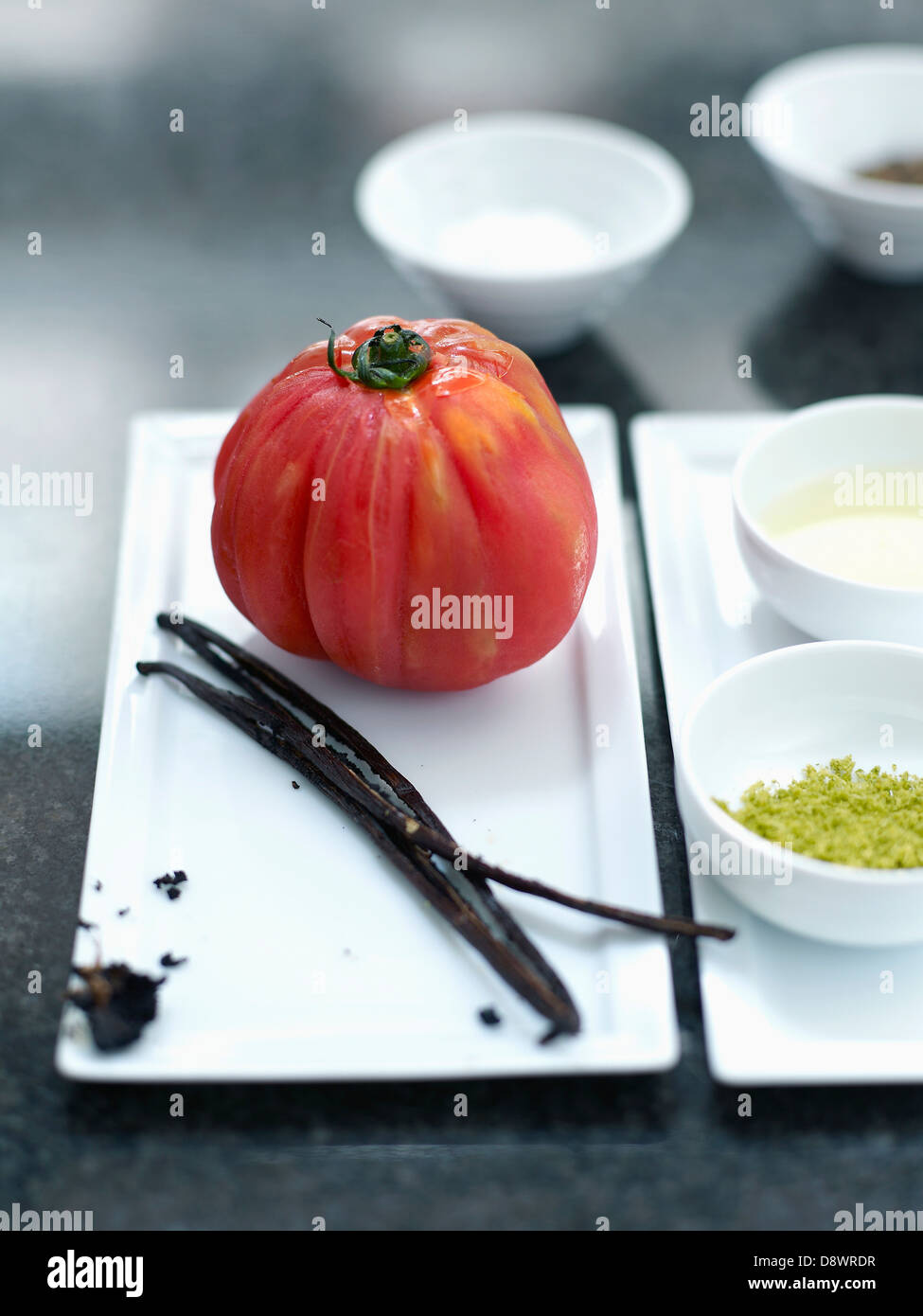 Ingredientes para el tomate en rodajas con aceite de oliva con sabor a vainilla y limón zests Foto de stock