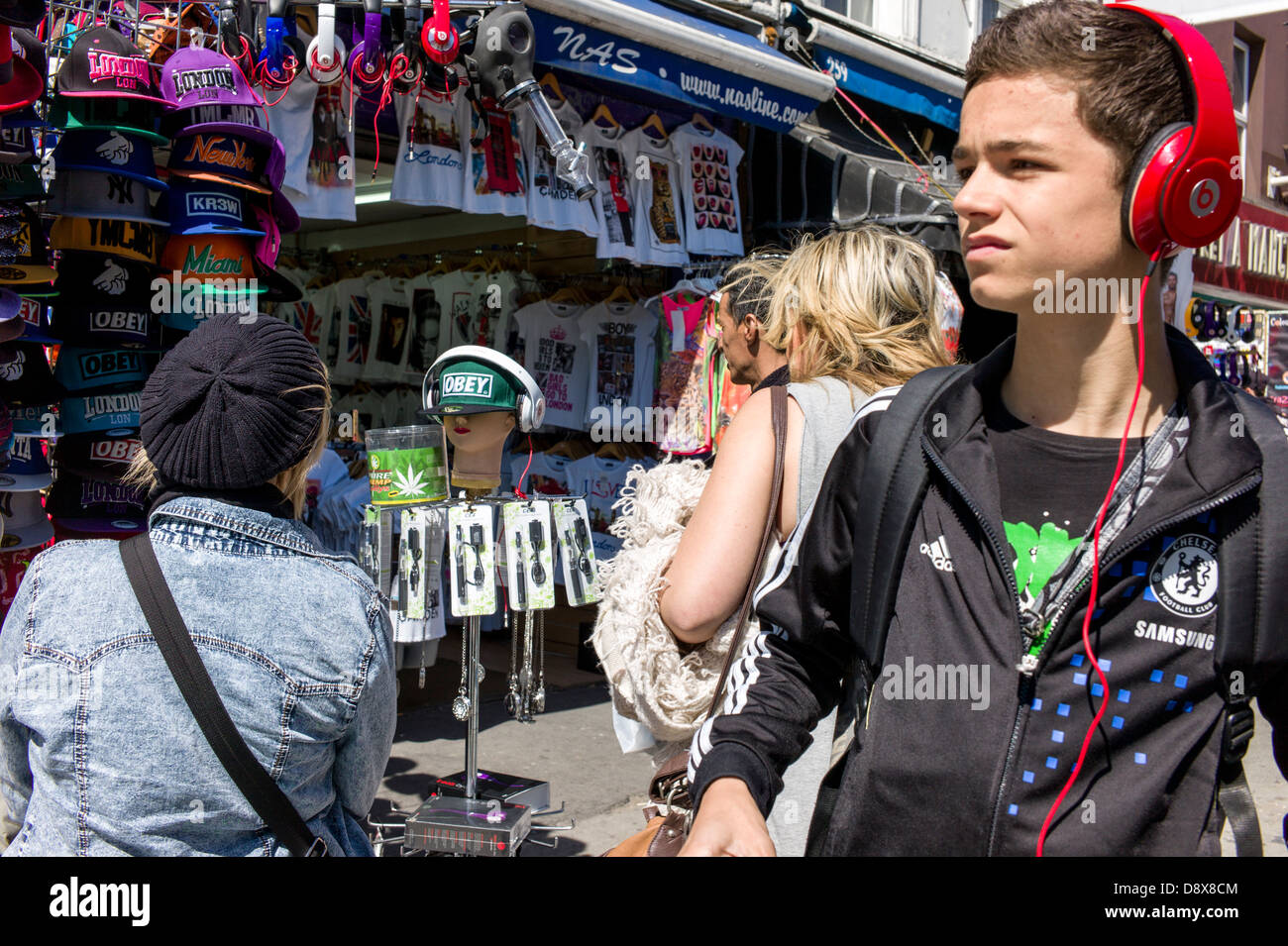 Londres, Reino Unido, Camden Town, el mercado de Camden, joven, hombre, usando audífonos, y turista, compradores, mirando los puestos de mercado Foto de stock