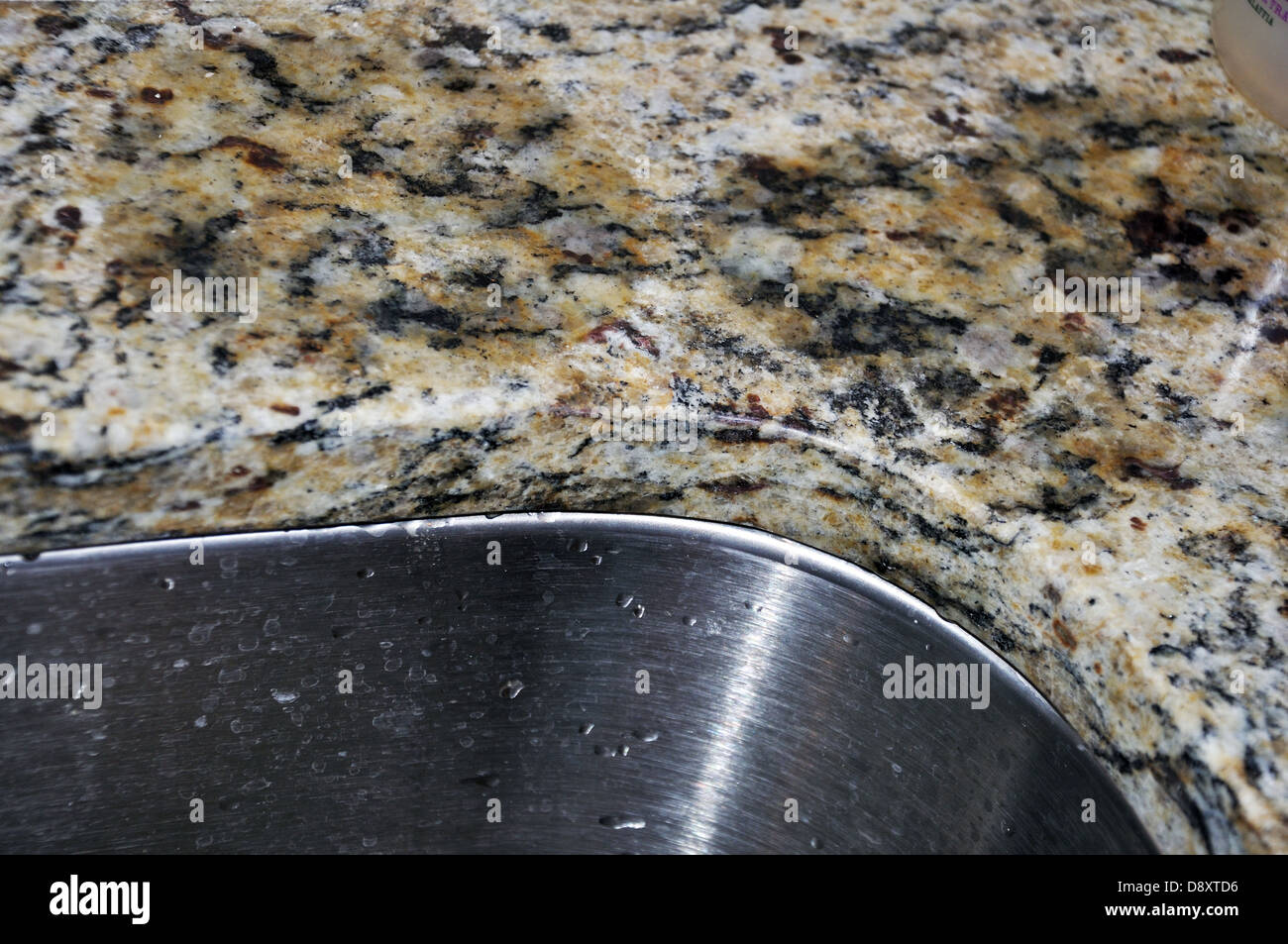 Las manchas de agua absorbida por la encimera de granito sobre el fregadero  de acero inoxidable en la cocina Fotografía de stock - Alamy