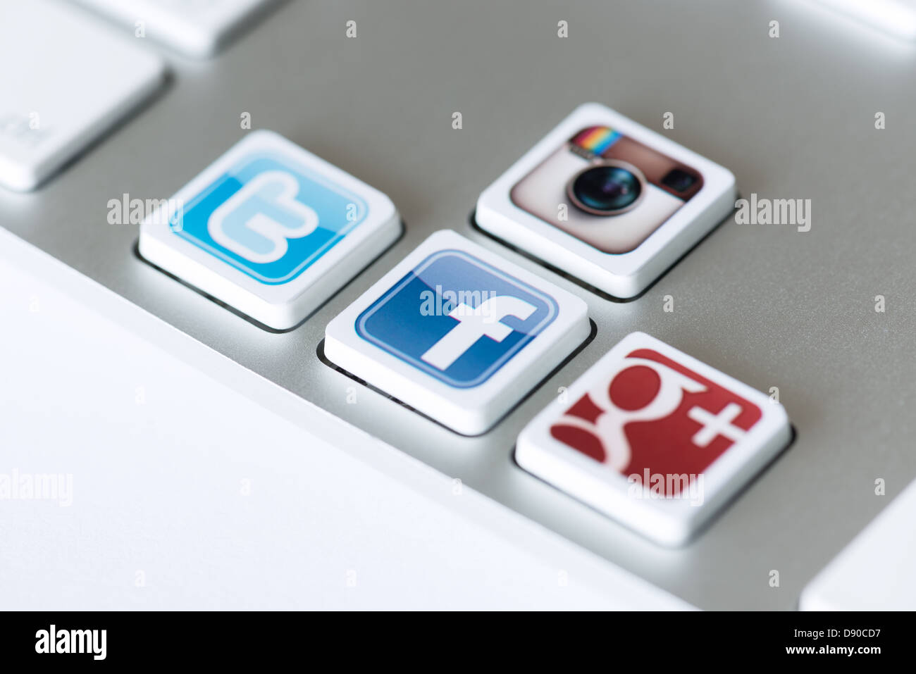 Iconos de medios sociales de Facebook, Twitter, Google Plus y Instagram colocados en las teclas del teclado de ordenador. Foto de stock