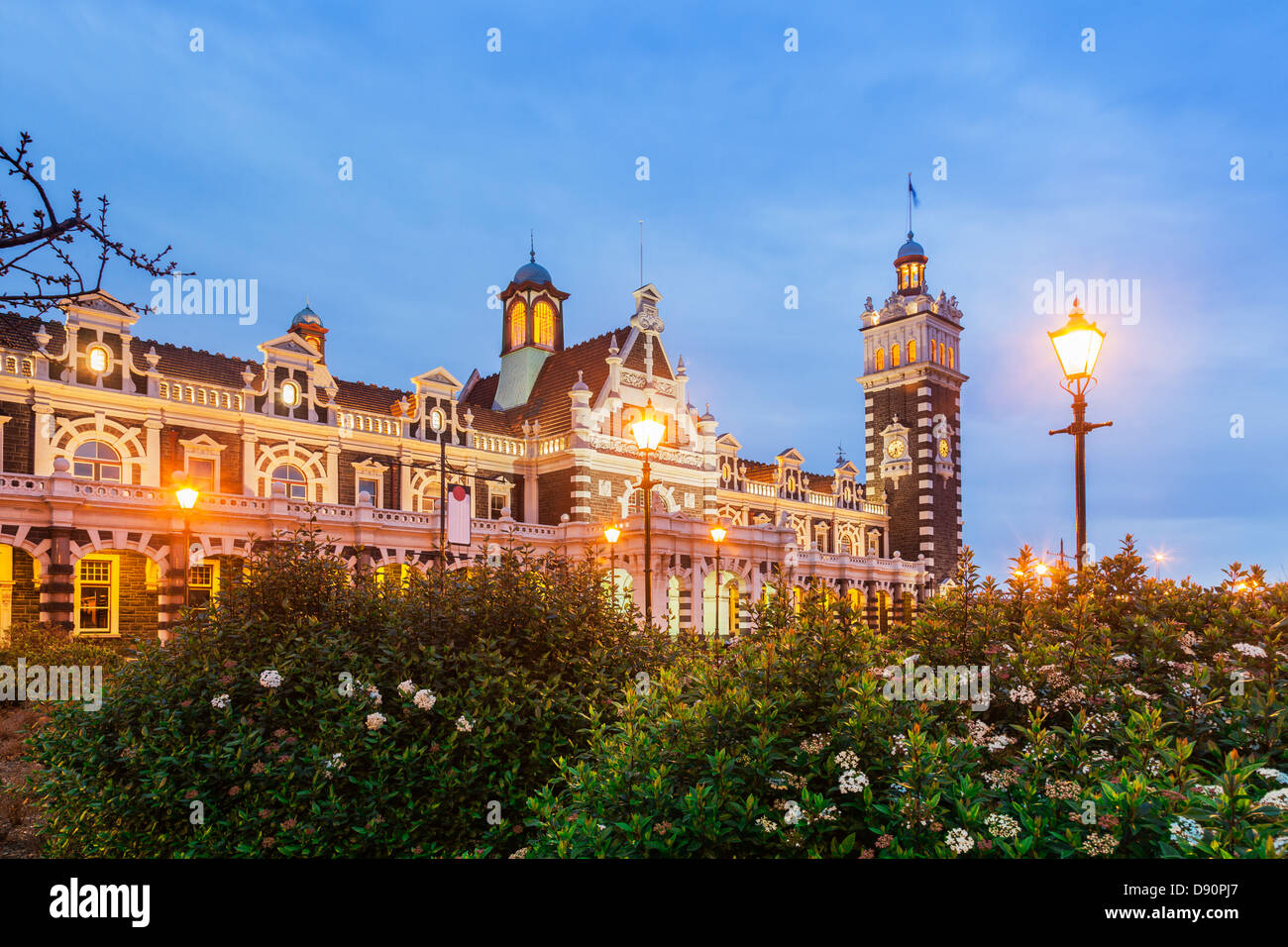 Dunedin Railway Station iluminada en penumbra. Foto de stock