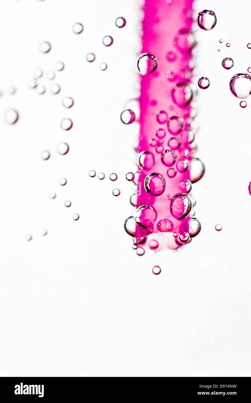Paja en agua potable rosa Foto de stock