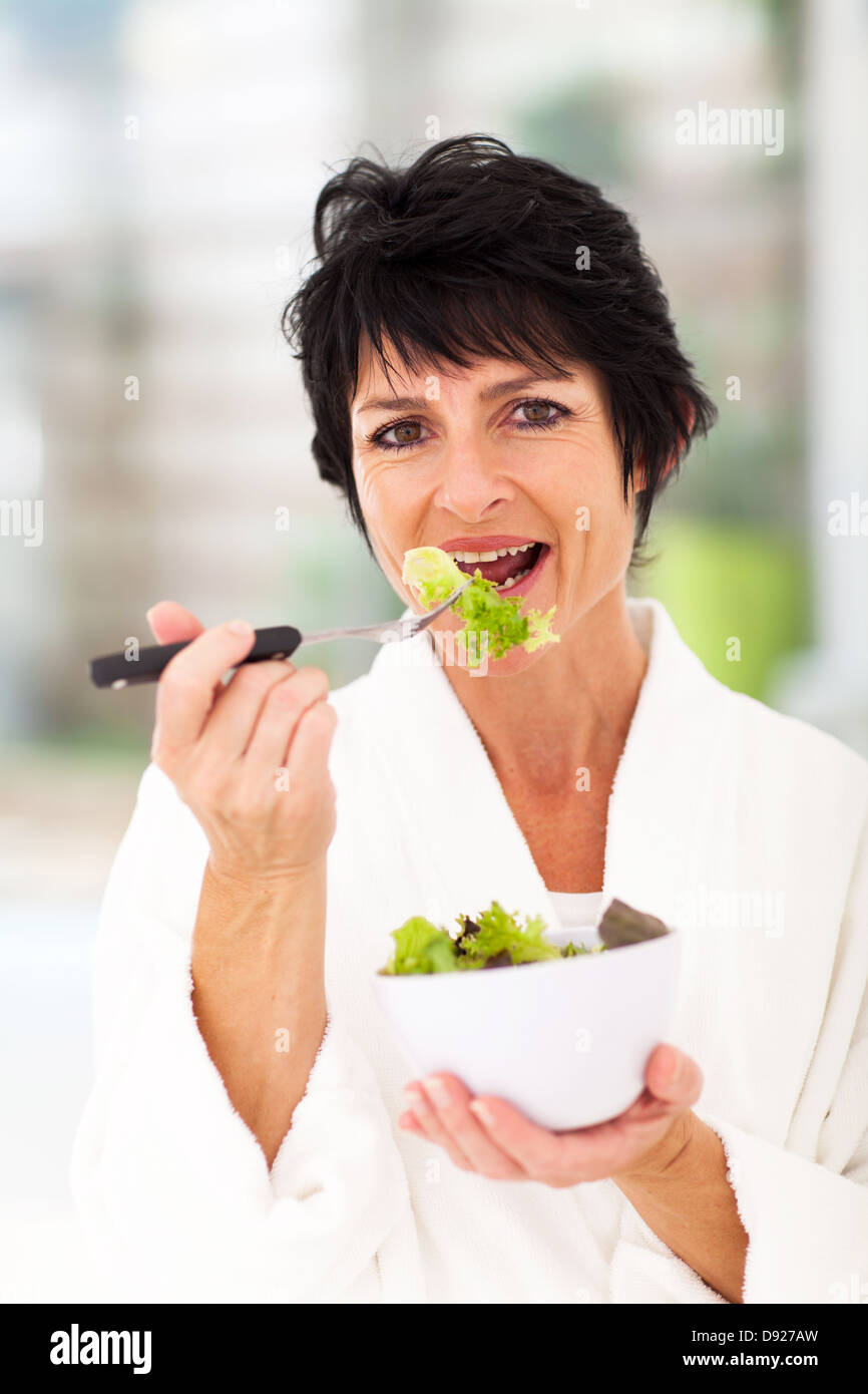 Mujer de mediana edad sano comer ensalada verde Foto de stock