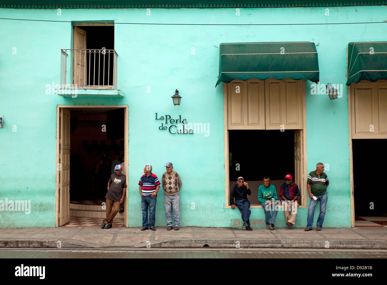 Los hombres locales en frente del restaurante La Perla de Cuba inCamagüey, Cuba, el Caribe, Foto de stock